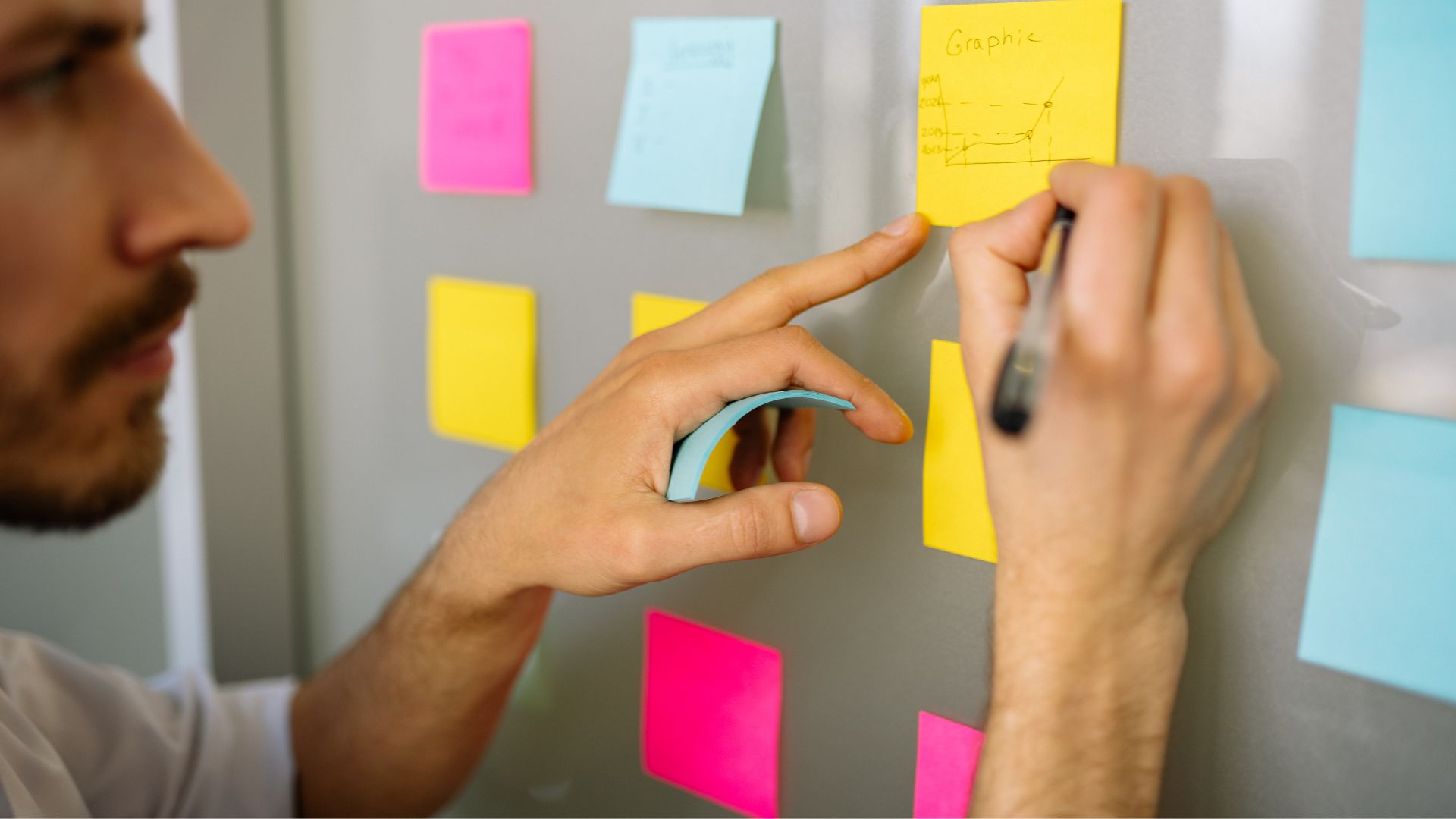 Man skriver på post-its vid whiteboard under strategiprocess för innovation och digitalisering